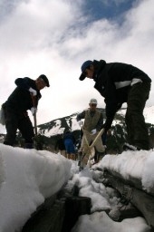 スコップで木道が見えるよう雪を取り除いた