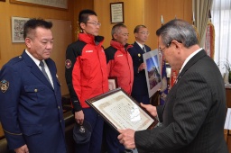 千明村長(右)から感謝状を贈られる署員ら
