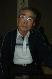 自宅で当時を振り返る塙さん