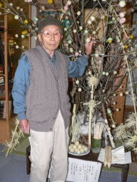 小正月飾りを前に「伝統継承が大事」と語る新井さん