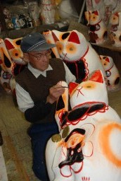 丁寧に招き猫を仕上げていく荻原さん