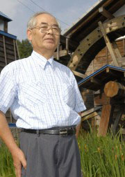 作品の素材に使った車の前に立つ関口さん