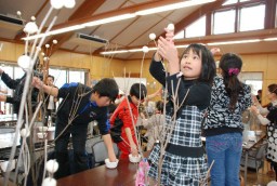 好みの枝に繭玉を飾り付ける参加者