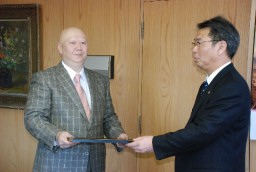 亀山市長から感謝状を受け取る新居さん(左)