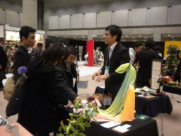 来場者に桐生のシルクを紹介する吉田さん(右)