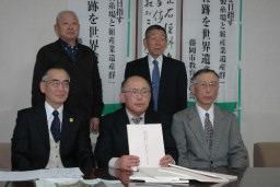 完成した解説書を持つ小坂会長(前列中央)や会員