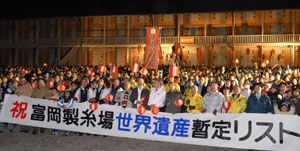 旧官営富岡製糸場・西繭倉庫の前で世界遺産登録の暫定リスト入りを喜ぶちょうちん行列の市民=23日午後6時半ごろ
