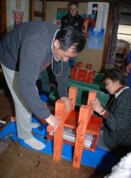 薄絹を挟んだ型板を枠にはめて締める作業