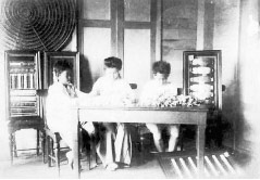 机の上に生糸の束を積み、タイで蚕糸技術を教える新井さわさん(中央)