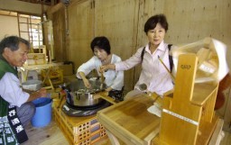 座繰り器の操作に挑戦する来場者