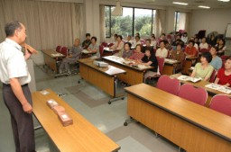 萩原さん(左)の説明に聞き入る参加者たち