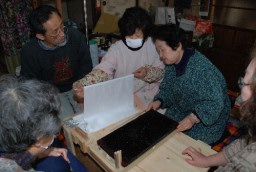 慎重に、型板に生地を挟むメンバー