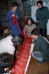 染め上がった作品を広げ、出来具合をチェック。染め残しやむらがないか確認する