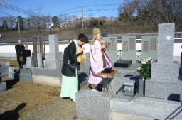 記念碑(奥)の完成を堅曹の墓前で報告する美智子さん(左)