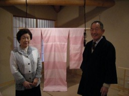 作品の前に立つ芝崎さん(右)と妻の美枝子さん