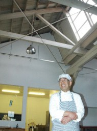 改装中の金谷レース工業鋸屋根工場内に立つ武田社長