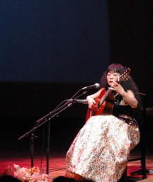 本県での住民との交流から生まれた曲を披露する篠崎さん