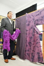 ムラサキで染めた作品を手にする石川さん