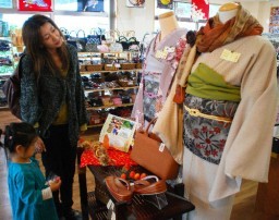 ファッションウイークの一環の創業祭で着物に見入る親子連れ