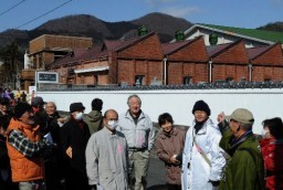 のこぎり屋根が特徴的な旧金谷レース工業について説明を受ける桐生町並み解説会の参加者