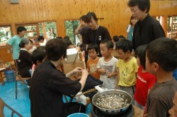 蚕や繭を興味深そうに見る来場者