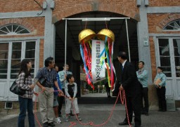 岡野市長と記念のくす玉を割る井坂さん一家(左側)