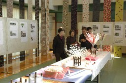 児童の養蚕への取り組みが紹介された展示を見学する来場者